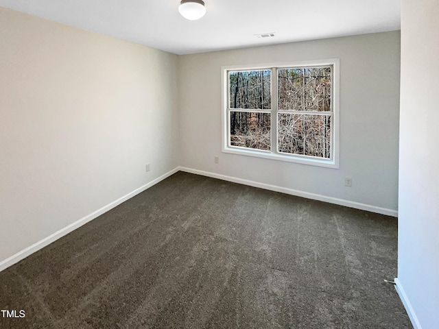 unfurnished room featuring dark carpet