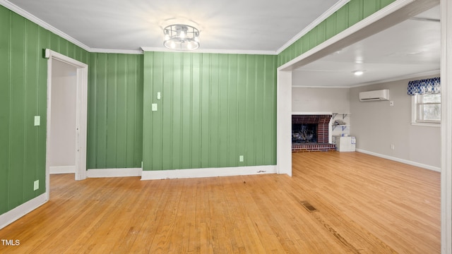 unfurnished living room featuring crown molding, wood-type flooring, a brick fireplace, and an AC wall unit