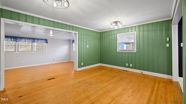 unfurnished room featuring crown molding and hardwood / wood-style floors