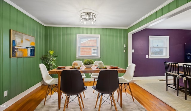 dining area with hardwood / wood-style flooring, crown molding, and a notable chandelier