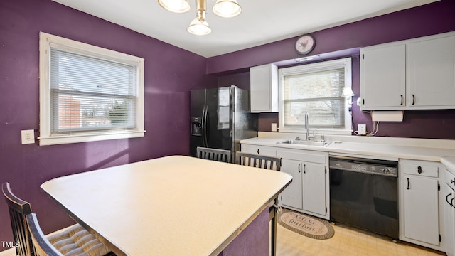 kitchen featuring sink, plenty of natural light, black appliances, and white cabinets