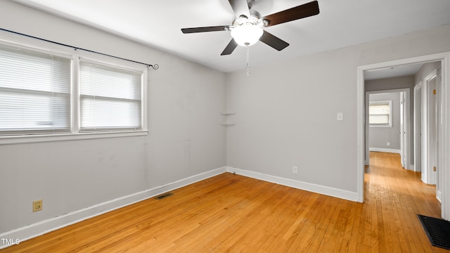 empty room with ceiling fan and light hardwood / wood-style flooring