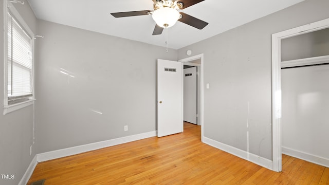 unfurnished bedroom with ceiling fan, a closet, and light wood-type flooring