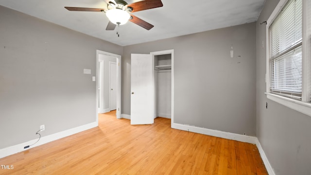 unfurnished bedroom featuring ceiling fan, light hardwood / wood-style floors, and a closet