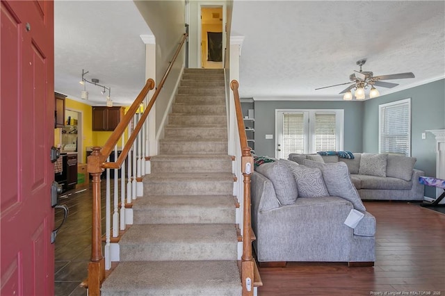 stairway with hardwood / wood-style floors, crown molding, a textured ceiling, and ceiling fan