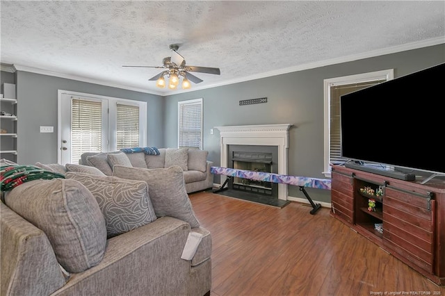 living room featuring crown molding, ceiling fan, hardwood / wood-style floors, and a textured ceiling