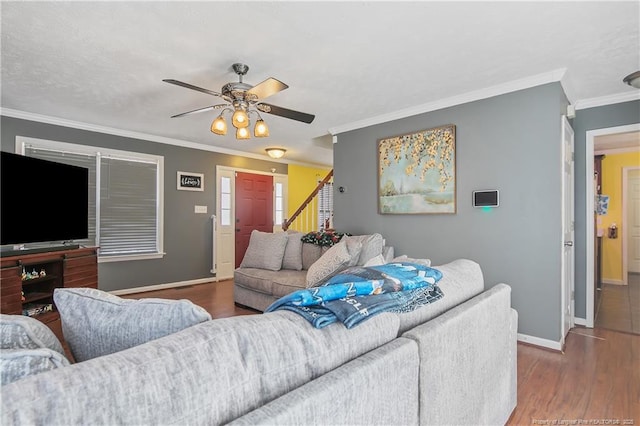 living room featuring hardwood / wood-style flooring, ornamental molding, and ceiling fan