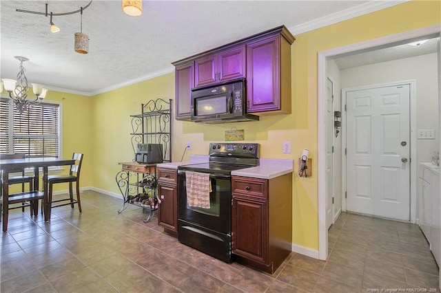 kitchen featuring an inviting chandelier, decorative light fixtures, washing machine and clothes dryer, black appliances, and a textured ceiling