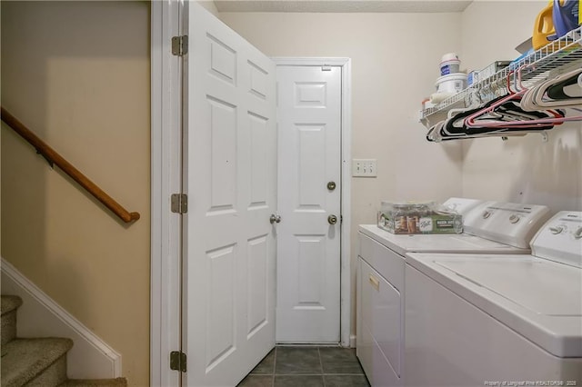 laundry room featuring dark tile patterned flooring and washing machine and dryer