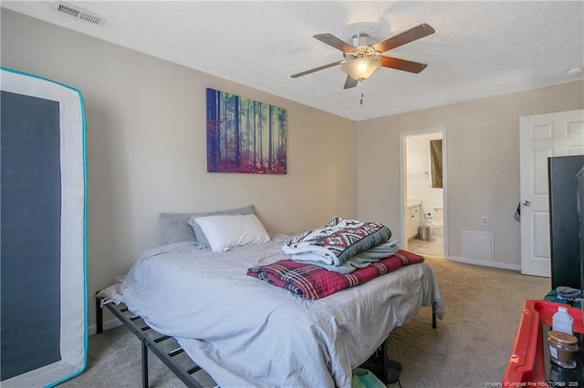 carpeted bedroom featuring ceiling fan, a textured ceiling, and ensuite bathroom