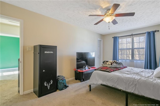 bedroom with ceiling fan, light carpet, and a textured ceiling