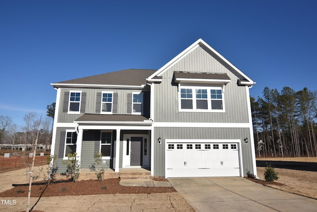 view of front of property featuring board and batten siding, roof with shingles, driveway, and an attached garage