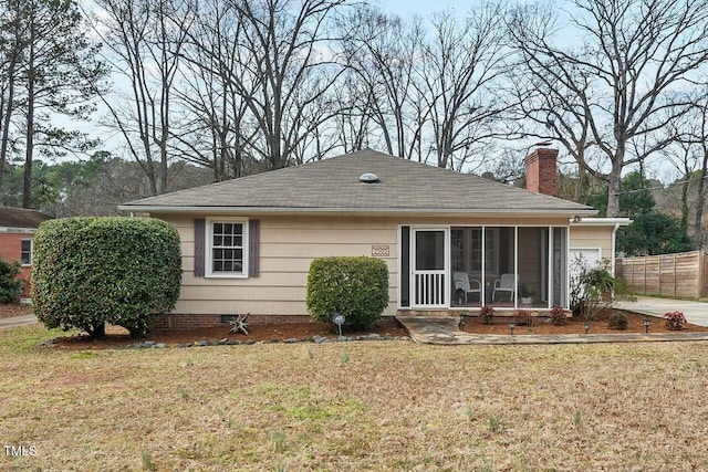 back of property featuring a lawn and a sunroom