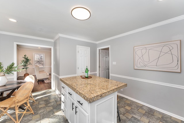 kitchen with ornamental molding, a center island, and white cabinets