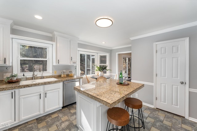 kitchen with white cabinetry, stainless steel dishwasher, sink, and a kitchen island