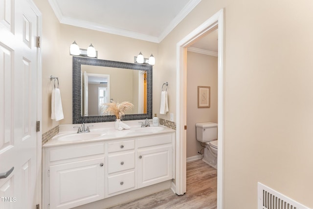 bathroom featuring crown molding, vanity, toilet, and hardwood / wood-style floors