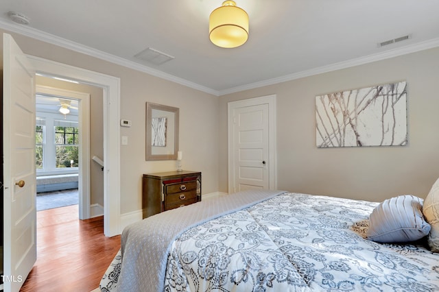 bedroom featuring ornamental molding and wood-type flooring