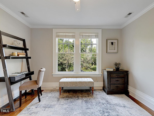 living area with wood-type flooring and ornamental molding