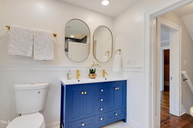 bathroom with hardwood / wood-style flooring, vanity, and toilet