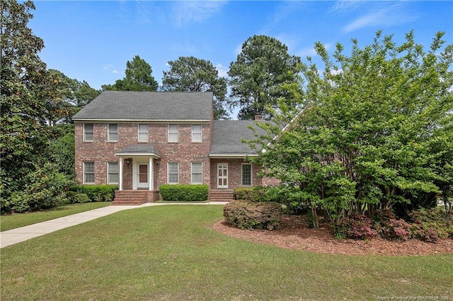 colonial home featuring a front lawn