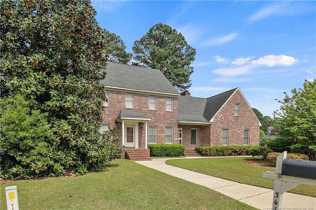 colonial-style house featuring a front yard