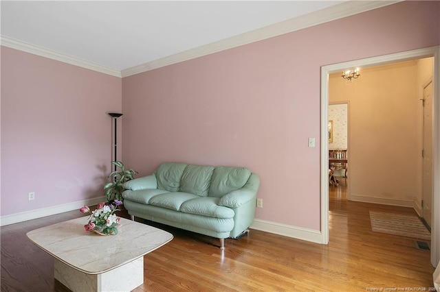 living room with crown molding, hardwood / wood-style flooring, and a chandelier