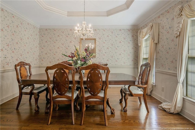 dining space with wood-type flooring, crown molding, a chandelier, and a tray ceiling