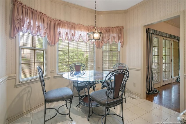 dining space with light tile patterned flooring and crown molding