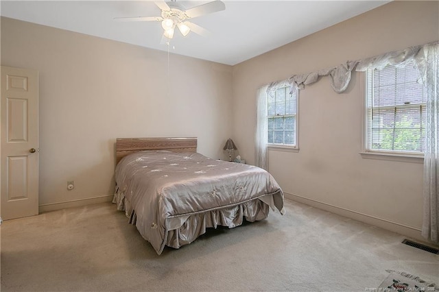 carpeted bedroom with multiple windows and ceiling fan