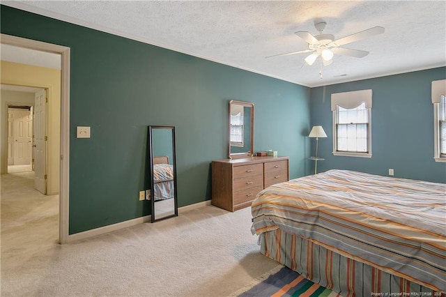 bedroom featuring ceiling fan, light colored carpet, crown molding, and a textured ceiling