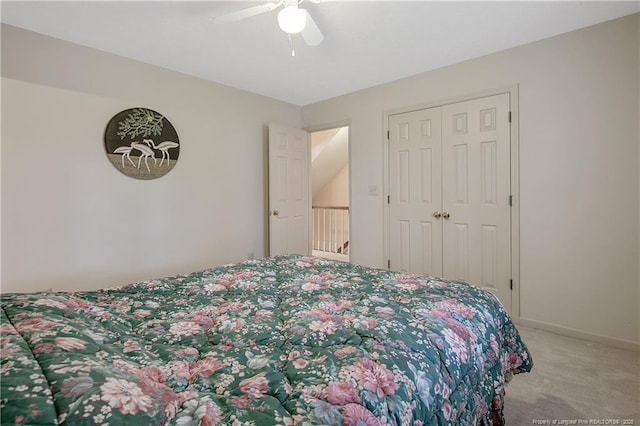 bedroom featuring light colored carpet, ceiling fan, and a closet