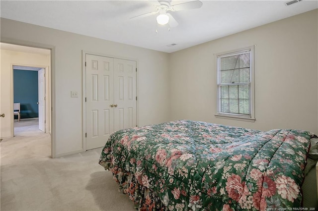 carpeted bedroom with ceiling fan and a closet