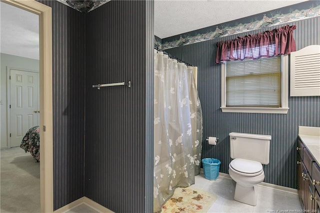 bathroom with tile patterned floors, toilet, a textured ceiling, vanity, and curtained shower