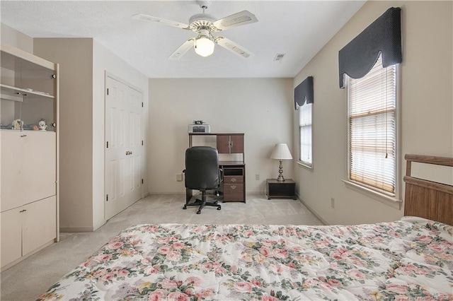 carpeted bedroom with multiple windows and ceiling fan