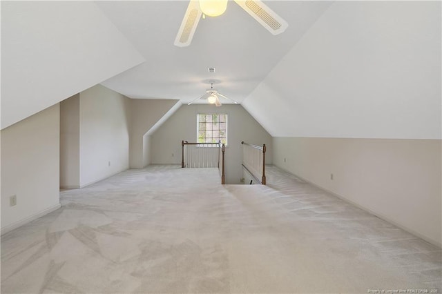 bonus room with vaulted ceiling, light colored carpet, and ceiling fan