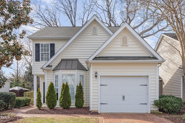 view of front of house with a garage, a shingled roof, and decorative driveway