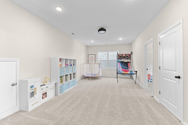 recreation room with light colored carpet