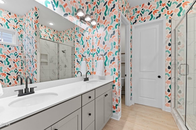 bathroom with vanity, wood-type flooring, a shower with door, and toilet