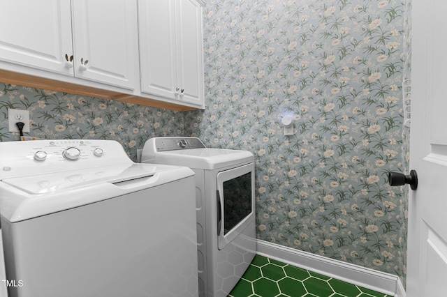 washroom with cabinets and washer and dryer