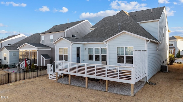 rear view of property with a wooden deck, a lawn, and central air condition unit