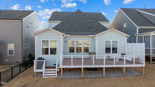 rear view of house with a wooden deck and a yard