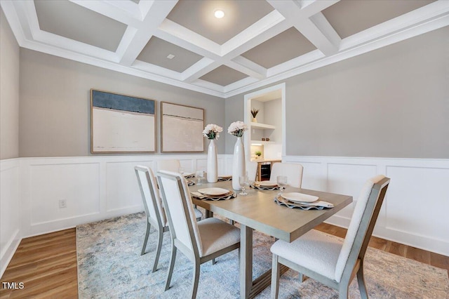 dining space featuring coffered ceiling, built in shelves, light hardwood / wood-style flooring, and beamed ceiling