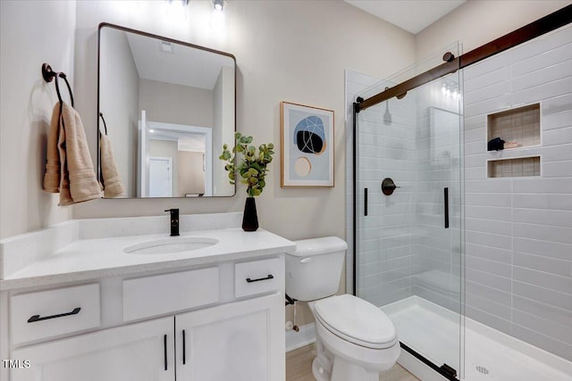 bathroom featuring vanity, toilet, and an enclosed shower