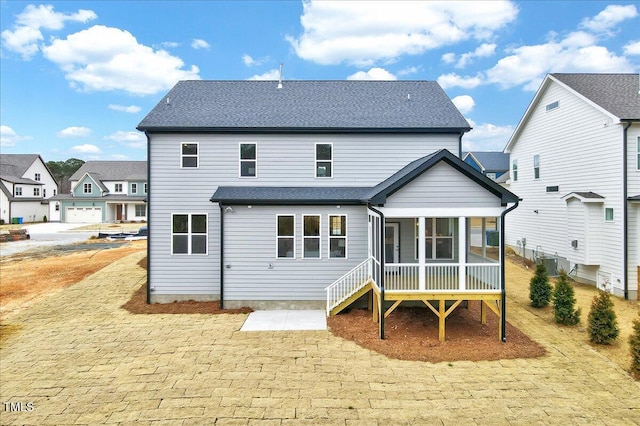 back of property with a sunroom, cooling unit, and a patio area