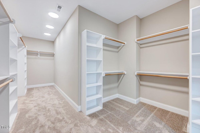 walk in closet featuring light carpet