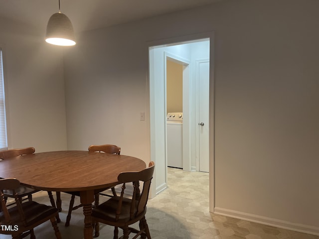 dining area with light floors, washer / clothes dryer, and baseboards