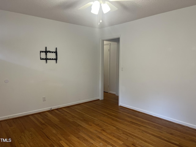 empty room featuring a ceiling fan, a textured ceiling, baseboards, and wood finished floors