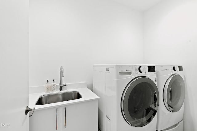 laundry room featuring washer and dryer, sink, and cabinets