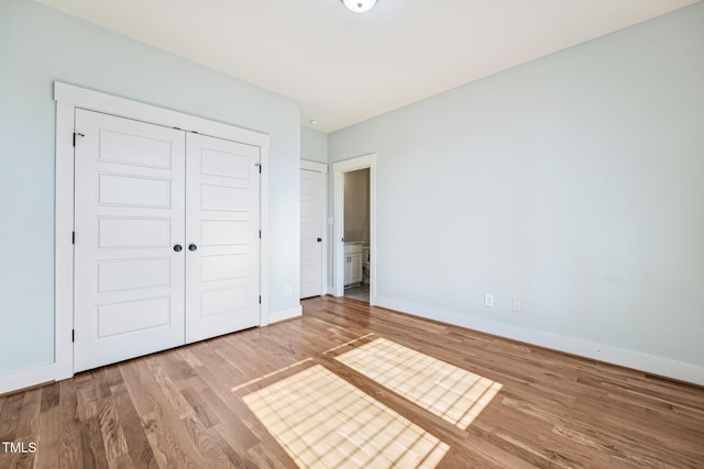 unfurnished bedroom with hardwood / wood-style floors and a closet