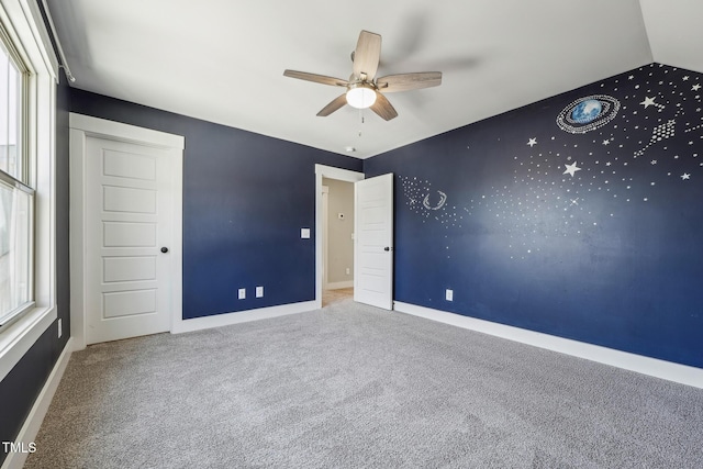 unfurnished bedroom with carpet, lofted ceiling, and ceiling fan